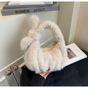 Gros plan détaillé d'un sac à main en peluche beige avec une anse nouée élégante