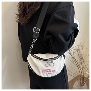 Dettaglio della borsa a mezzaluna in tela bianca con ricamo rosa e tracolla nera