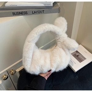 Détail d'un sac à main blanc en fausse fourrure de lapin avec des oreilles de lapin décoratives