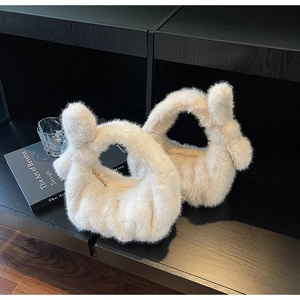 Détail du sac à main en peluche blanc cassé avec poignée nouée et texture douce