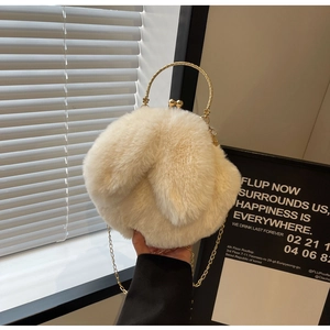Détail du sac lapin en peluche avec anneaux dorés et bandoulière en fausse fourrure crème