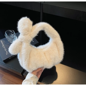 Détail du sac à main en fausse fourrure crème douce avec une poignée nouée unique