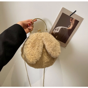 Détail du sac lapin en peluche montrant l'anse dorée et le fermoir rétro en métal