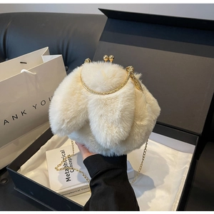 Détail du sac en peluche blanc avec oreilles de lapin, fermoir métal et chaîne dorée
