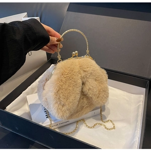 Détail du sac lapin en peluche avec poignée dorée dans une boîte cadeau en soie