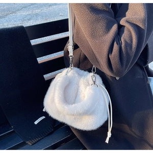 Détail d'un sac bandoulière en fausse fourrure blanche avec cordon et boucles en métal argenté