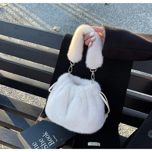 Détail du sac seau en fausse fourrure blanche avec texture pelucheuse et fermoirs argentés