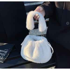 Détail du sac seau en fausse fourrure blanche avec poignée en peluche et boucles argentées
