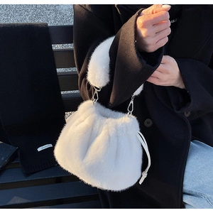Gros plan du sac seau en peluche blanche avec cordon de serrage et poignée épaisse en fourrure