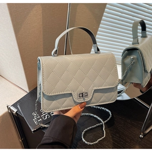 Detailed view of quilted leather texture and silver rectangular twist lock on light blue bag