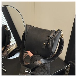 Detail van zwarte PU-leren crossbodytas met brede geweven band en FASHION logo