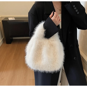 Détail d'un sac à main en peluche blanche douce et moelleuse porté avec un manteau noir