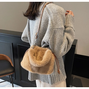 Sac bandoulière en fausse fourrure marron avec fine sangle sur un pull en maille grise