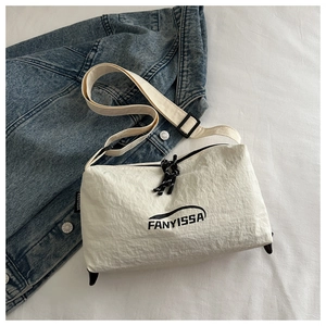 Détail du sac bandoulière en nylon blanc avec logo FANYISSA noir et bandoulière réglable