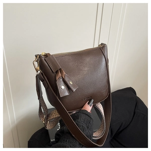 Detail van donkerbruine crossbodytas met brede schouderband en FASHION tekst
