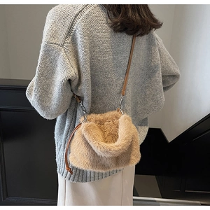 Détail du sac seau en fausse fourrure marron clair avec bandoulière en cuir et crochets