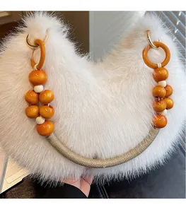 Détail du sac croissant en fausse fourrure blanche avec bandoulière en perles de bois