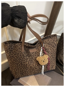 Dettaglio della borsa leopardata con manici marroni e ciondolo orsetto di peluche
