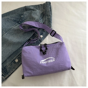 Détail du sac bandoulière en nylon violet avec logo et tirette de zip tressée