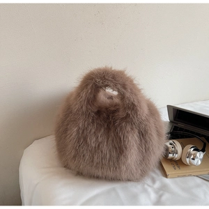 Détail d'un sac à main en fausse fourrure de renard marron avec texture douce d'automne