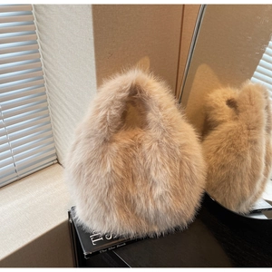 Détail de la texture en fausse fourrure beige d'un sac à bandoulière en peluche doux