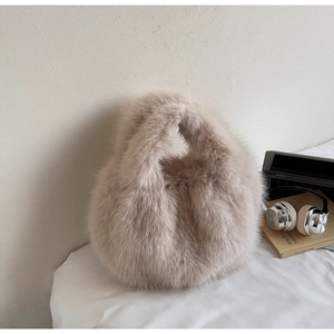 Détail de la texture en fausse fourrure de renard beige sur un sac à main doux et luxueux