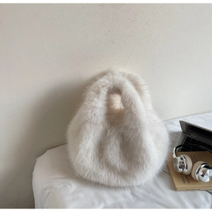 Détail d'un sac à main blanc en fausse fourrure avec texture pelucheuse pour l'hiver