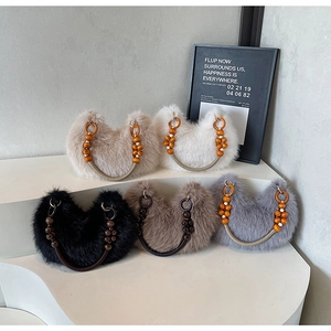 Détail des sacs demi-lune en peluche avec poignées perlées en cinq coloris différents