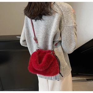 Détail d'un sac à main rouge en fausse fourrure duveteuse porté par un mannequin