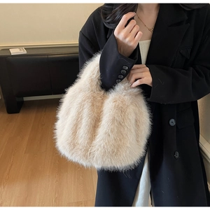Détail d'un sac à main en fausse fourrure beige porté par un mannequin en veste noire