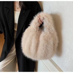 Détail d'un sac à main en fausse fourrure beige porté par un mannequin pour l'automne