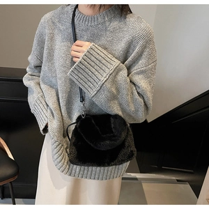 Détail du sac bandoulière en peluche noire avec fine sangle et boucle de fermeture métal