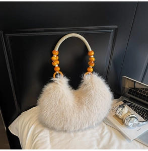 Détail du sac fourre-tout beige en fausse fourrure avec poignée en corde tressée et perles
