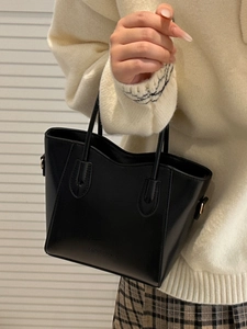 Fashionable black PU leather bucket bag with top handle and detachable strap in a soft light