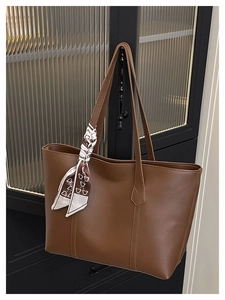 Close-up of brown large tote bag in matte PU leather with printed silk scarf on handle