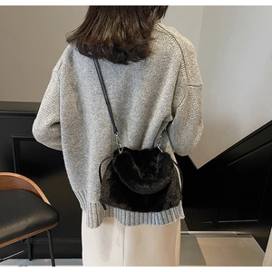 Détail du sac bandoulière en fausse fourrure noire avec texture peluche et boucles