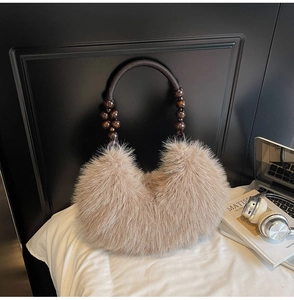 Détail du sac croissant en fausse fourrure marron clair avec anses tressées et perles