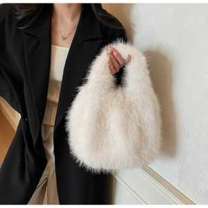 Détail de la texture douce en fausse fourrure blanche d'un sac à main porté à l'épaule
