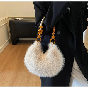 Détail du sac croissant en peluche beige avec poignée en perles de bois et anneaux