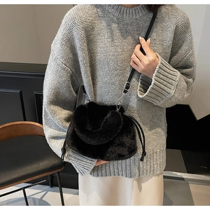 Détail du sac seau noir en fausse fourrure avec cordon de serrage et boucle en argent