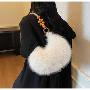 Détail du sac croissant en fausse fourrure blanche avec bandoulière perlée et texture douce