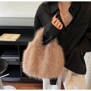 Détail d'un sac à main en fausse fourrure marron avec un nœud doré décoratif chic