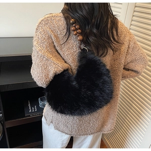Sac hobo en fausse fourrure noire avec bandoulière en perles de bois sur mannequin
