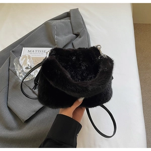 Détail du sac bandoulière en fausse fourrure noire avec lanière en cuir et métal