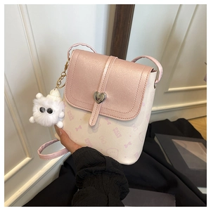 Detailed close-up of pink heart-lock crossbody bag with a cute white plush monster charm