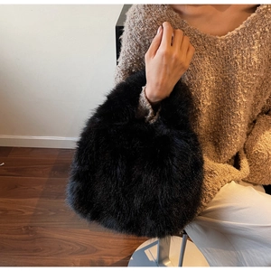 Gros plan du sac à main noir en fourrure synthétique avec poignée en peluche chic