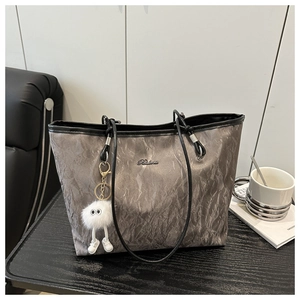 Detail of grey pleated tote bag with Balina metal logo and plush monster charm