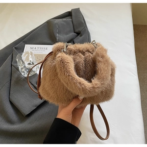 Détail d'un sac seau en fausse fourrure marron avec bandoulière en cuir et crochets