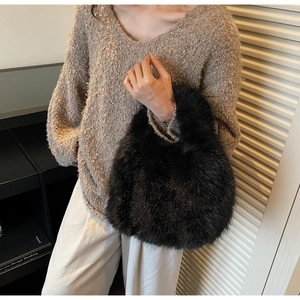 Détail de la texture en fausse fourrure noire sur un sac à main en peluche douce