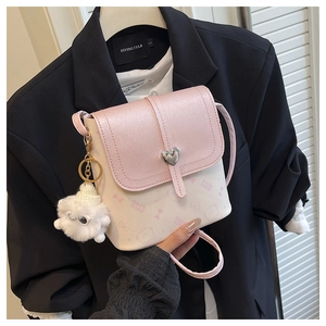 Detail of pink and white crossbody bag with heart buckle and cartoon duck print